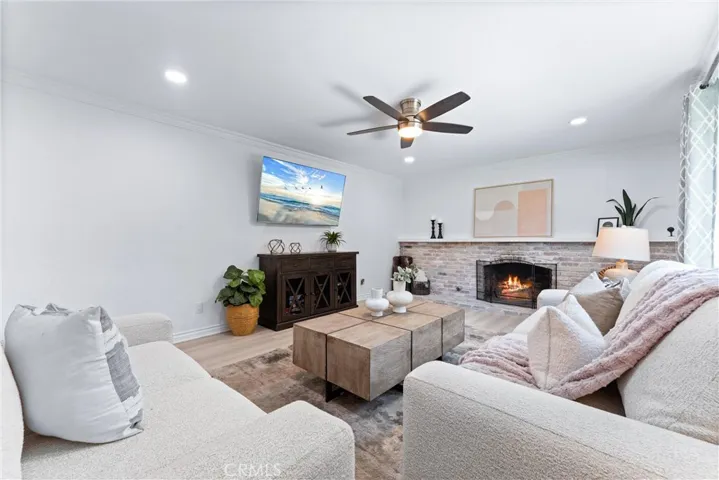 Living room has neutral color palette, crown moulding, new LVP flooring, and gas fireplace!