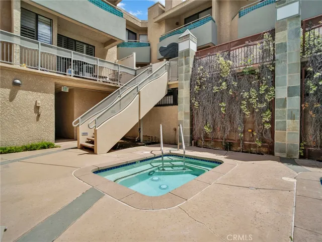 Community spa with an adjacent staircase, leading to an additional seating and lounge space