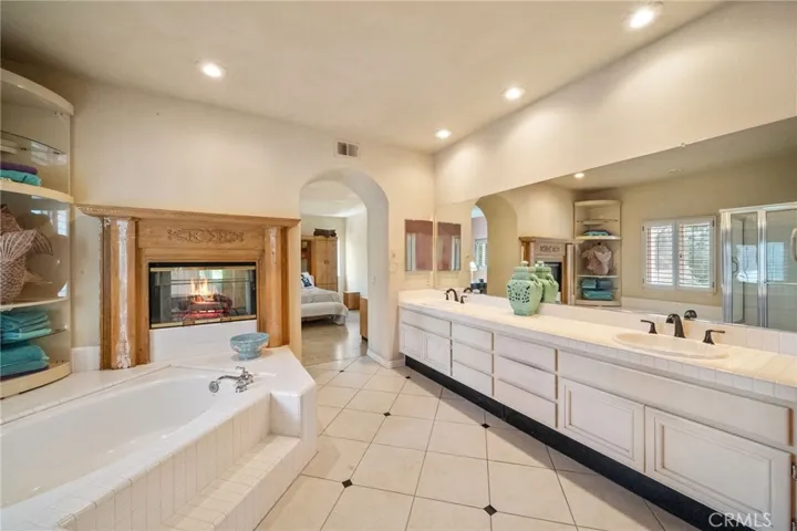 Primary Suite bathroom, with separate soaking tub and fireplace.