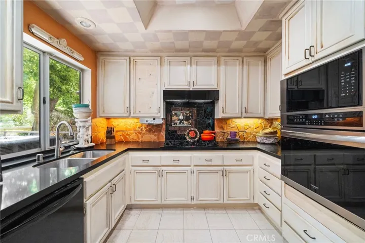 Remodeled kitchen with newer appliances and black granite counters.