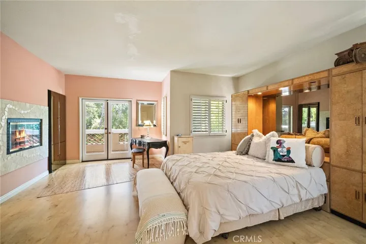 Primary Suite, with walk-in closet, two sided fireplace and 
French doors to balcony.