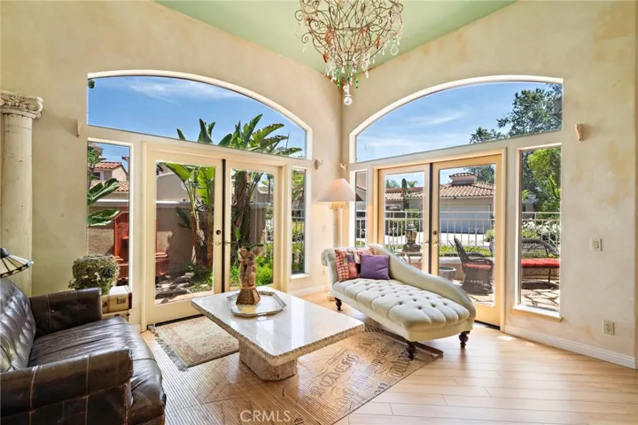 Area off to the side of the Great room with two sets of French doors and view of the fountain.