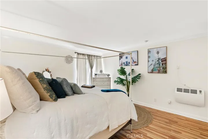 Master bedroom with laminated floor and large window