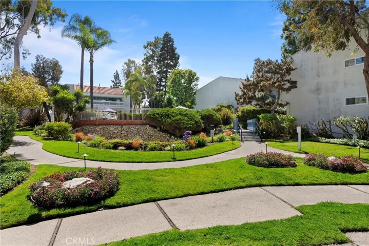 Grass area with water fountain and clubhouse behind