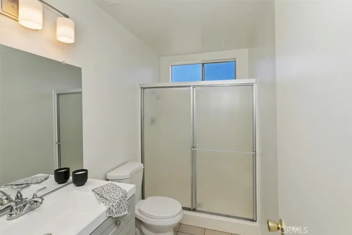 Updated primary bath with new vanity, toilet, lighting and tile.
