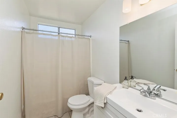 Updated guest bath with new vanity, toilet, lighting and tile.