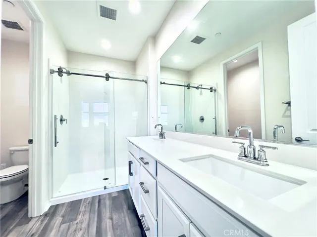 Primary bedroom bath with dual sinks and standing shower