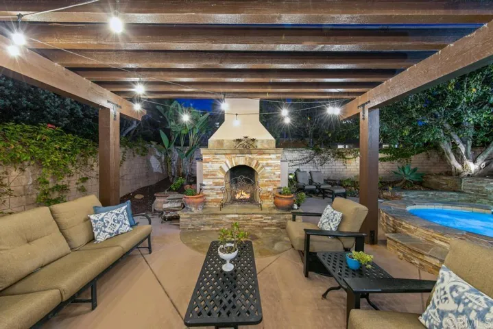 Fun trellis covered outdoor fireplace area for entertaining.