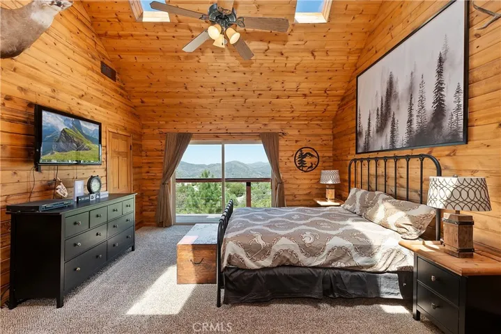 Main Level Primary Bedroom With River Rock Fireplace And Main Deck Access