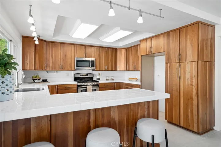 Modernized & completely renovated chef's kitchen w/ updated cabinetry, new sink, chic tile counter tops & newer stainless-steel appliances