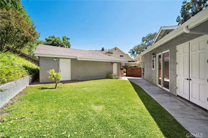 The side yard offers access to the finished flex room on the back of the garage for extra storage and the double doors to the right houses a tool/garden closet.