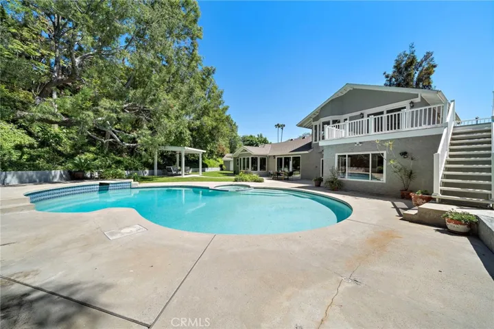 Pool and spa with stairs on right leading to primary bedroom deck