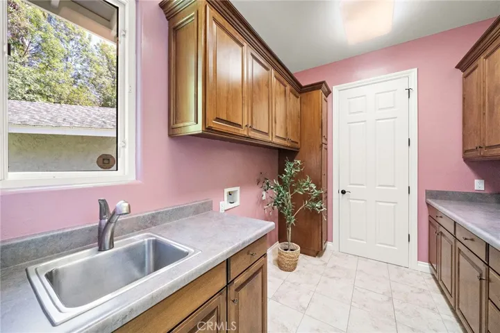 Utility/laundry room with storage and door to walk-in pantry