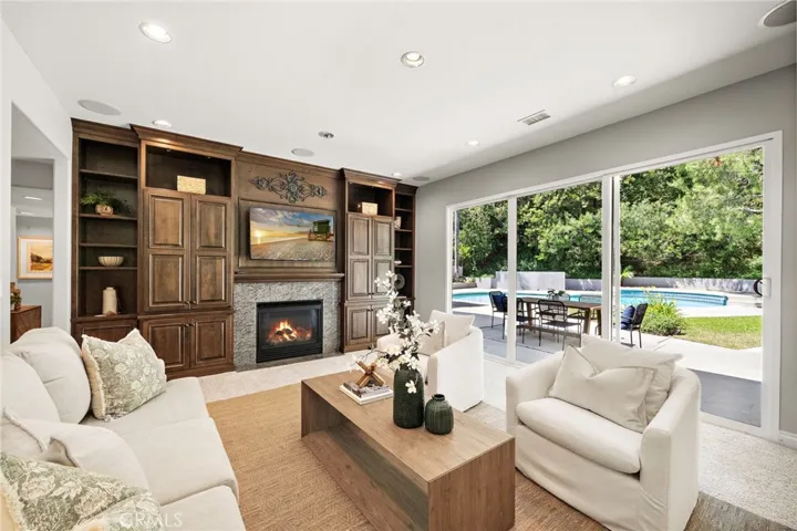 Family room with custom built-ins, fireplace, slider door to backyard retreat