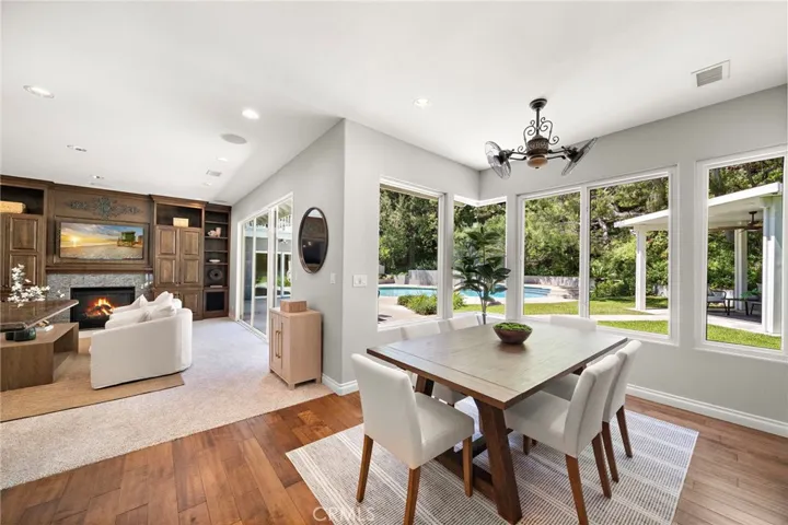 Dining off of kitchen with wall of windows and view to backyard and family room