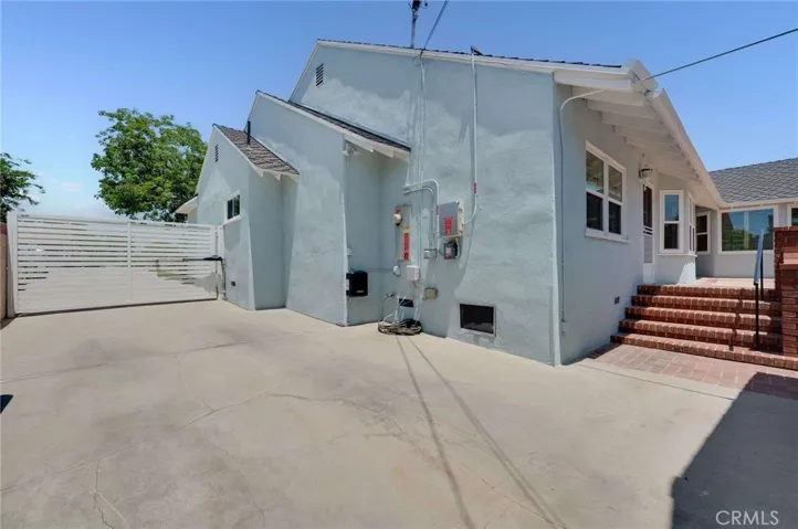 Large driveway with automatic controlled gate and EV Charger on the side of the house
