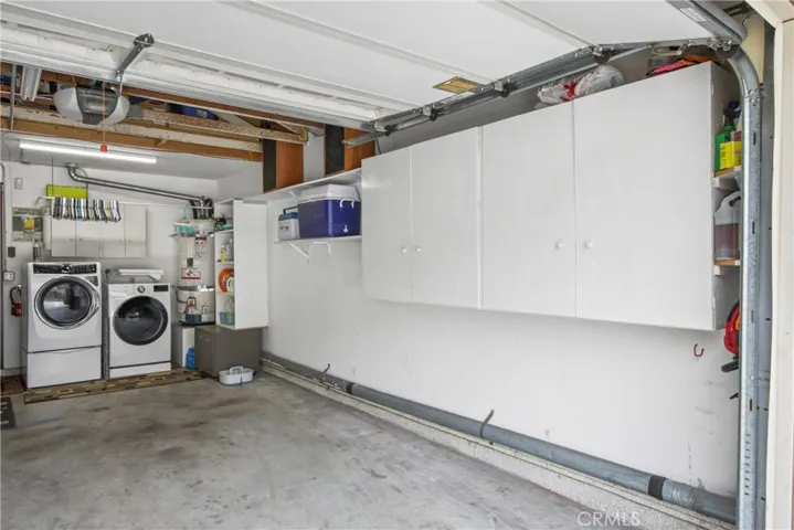 Laundry in garage with storage cabinets