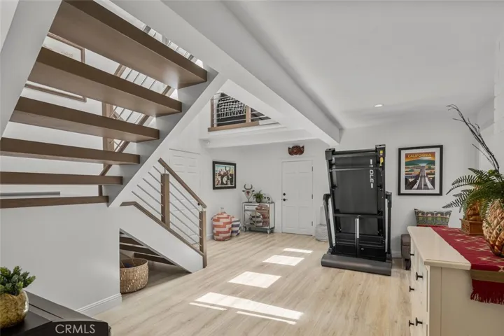 To the left of the Treadmill is the Garage entrance. This room had added support put in for loft super-support. The door at the bottom of the stairs on left is Primary Bedroom entry.