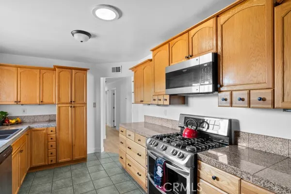 Kitchen, gas range with granite tile countertops