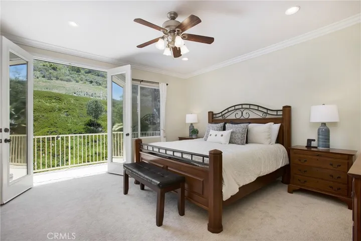 Primary suite with ceiling fan, crown moulding, balcony and complete privacy