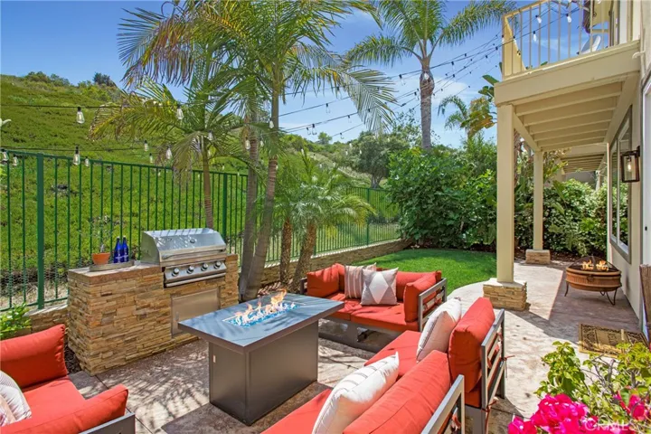 Private yard with Built in BBQ island, bistro lighting, firepit and sectional seating