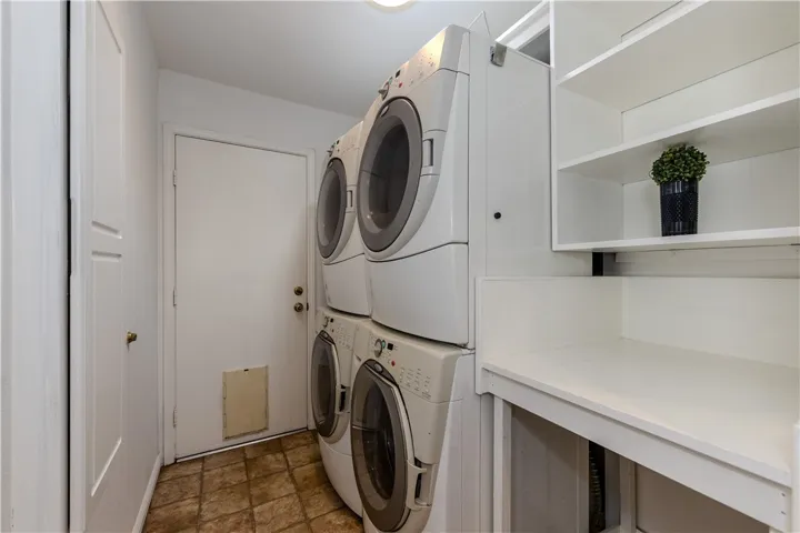 Inside laundry room leads to garage; dual washers & dryers included! Room has its own built-in ironing board (seen at left) & mini-skylight