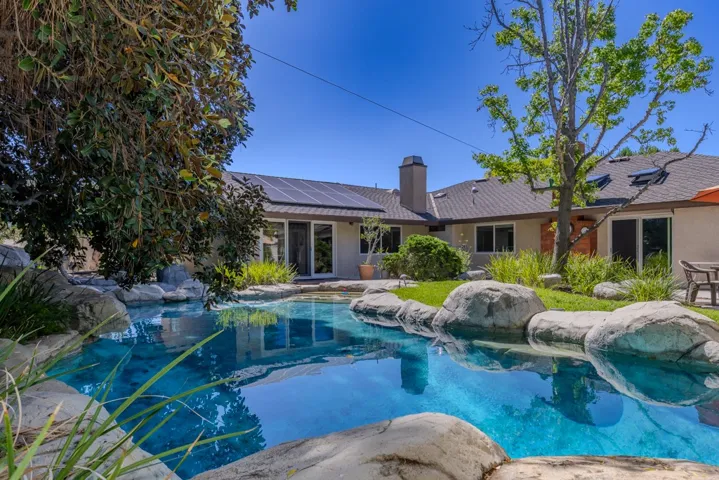 pool and primary suite as seen from west side of yard near tire swing