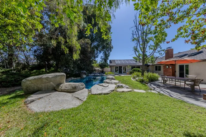 shot from west side backyard looking towards pool and primary suite