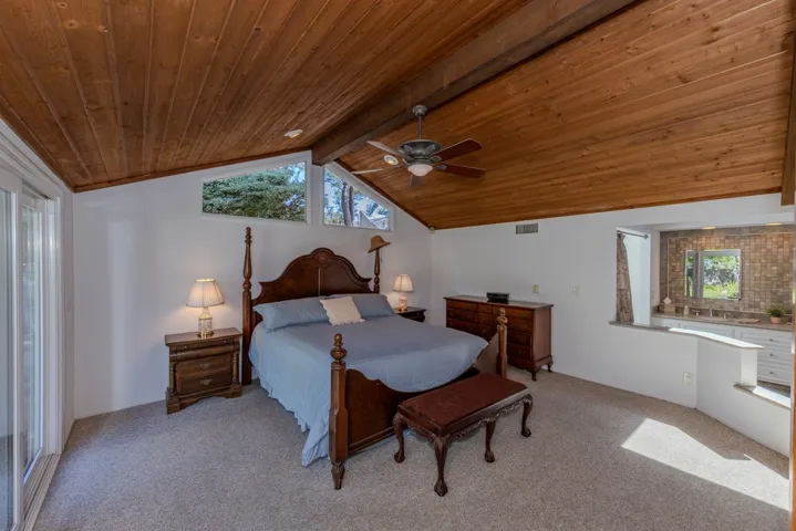 upper bed area of primary suite; slider at left goes out to backyard + pool/spa