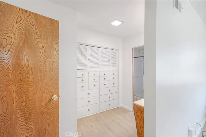 Dressing area in with built-in cabinetry and a vanity.