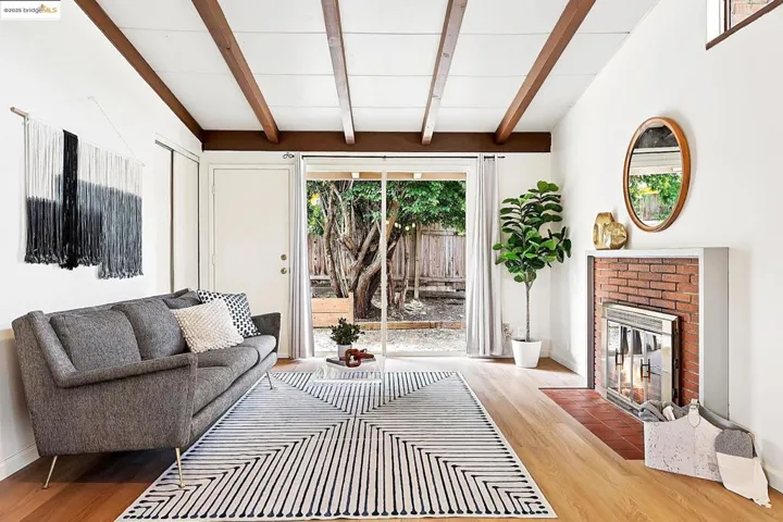Cozy living room with exposed beam ceiling and a classic brick fireplace