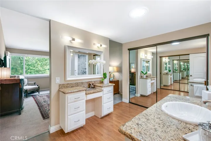 Upstairs Primary bathroom including quartz counters, vanity mirror and makeup quartz counter and one of two mirrored closet sliders.