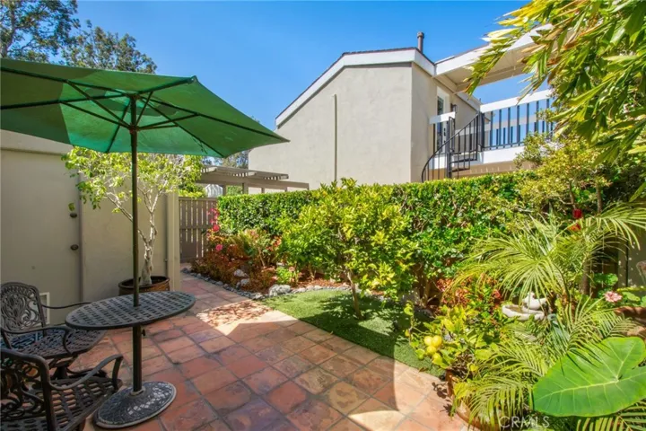 Front patio including terracotta tile and entry door to garage.