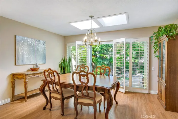 Dining room area including skylight, dual pane sliders and plantation shutters to back patio.