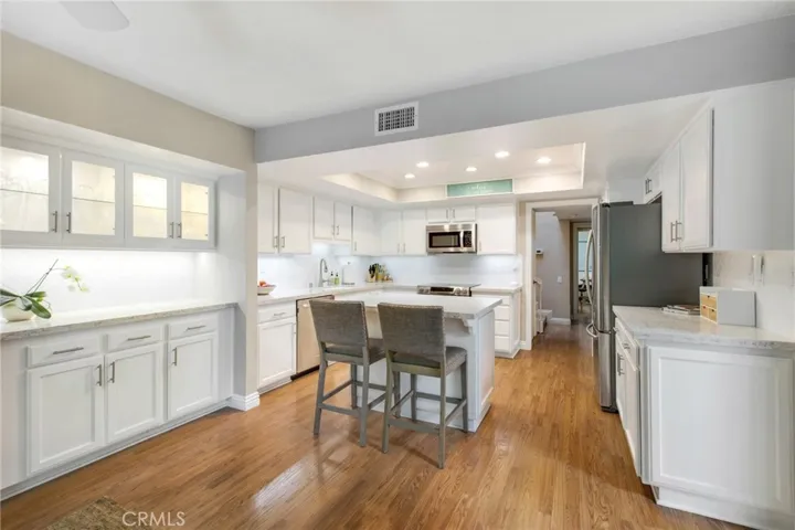 View from family room to kitchen including small island, plenty of counter spaces, storage and glass cabinets to show off your fine china.