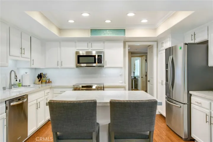 Kitchen view including stainless steel appliances and recessed lighting.