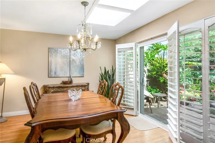 Dining room space including skylights and dual pane sliders and plantation shutters to back patio.