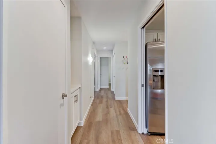 A hallway leads to the entrance and the bedrooms, which are at the back of the unit