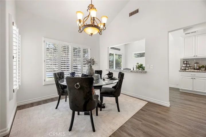 Dining room has an open cut out and pass through, with large picture windows