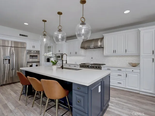 Central island with quartz countertops and pendant lighting above.
