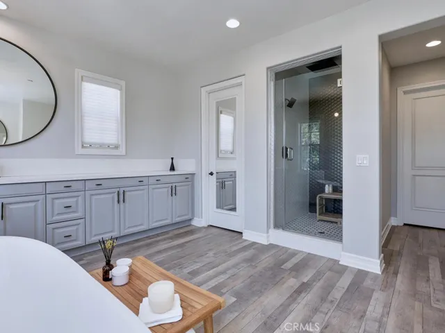 The mirrored door to the left and the other door to the right, lead to the two walk in closet areas-joined in the center. Custom tile in the shower.