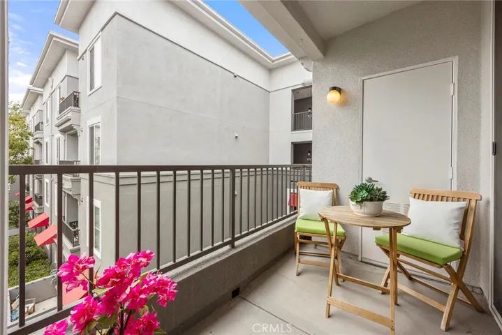 This interior unit is quietly nestled within the building and features a private balcony that overlooks a serene courtyard, perfect for morning coffee or relaxing outdoor dining.