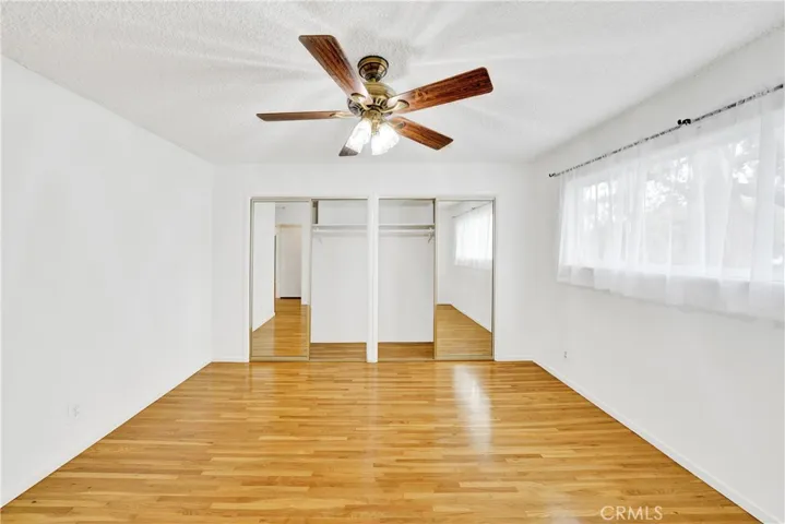 The bedroom has mirrored closet doors and built in shelves