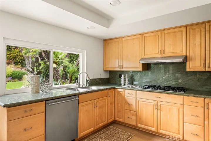 The kitchen features a five burner gas stove top.