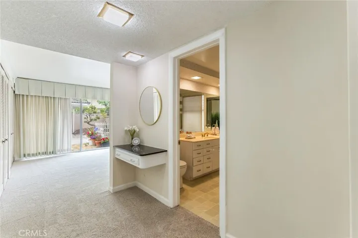 Mirrored wardrobe doors with extra storage in entrance to the primary bedroom