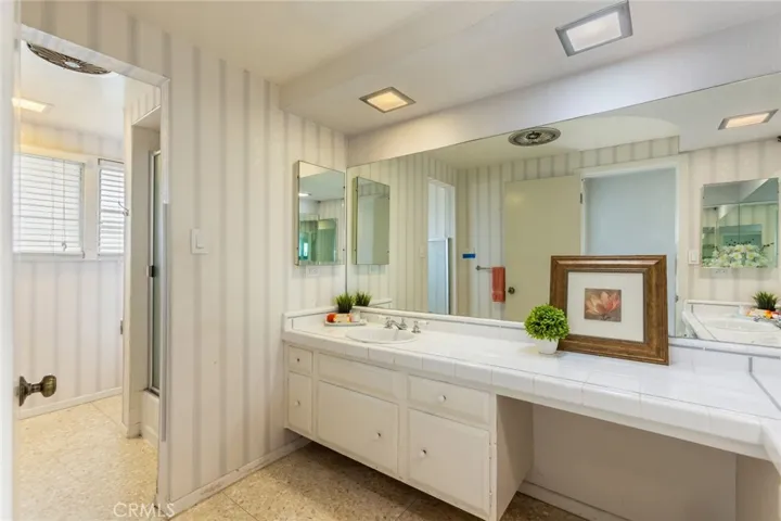 Terrazzo flooring in vanity and shower/toilet areas of the shared bath