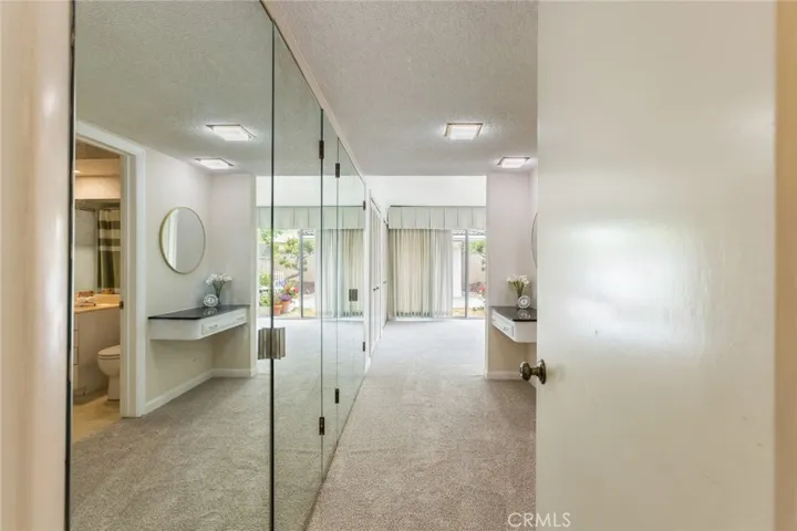 Mirrored wardrobe doors with extra storage in entrance to the primary bedroom