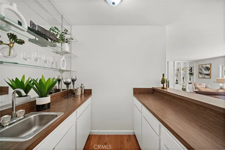 Wet bar with storage, seating ad glass display shelves.