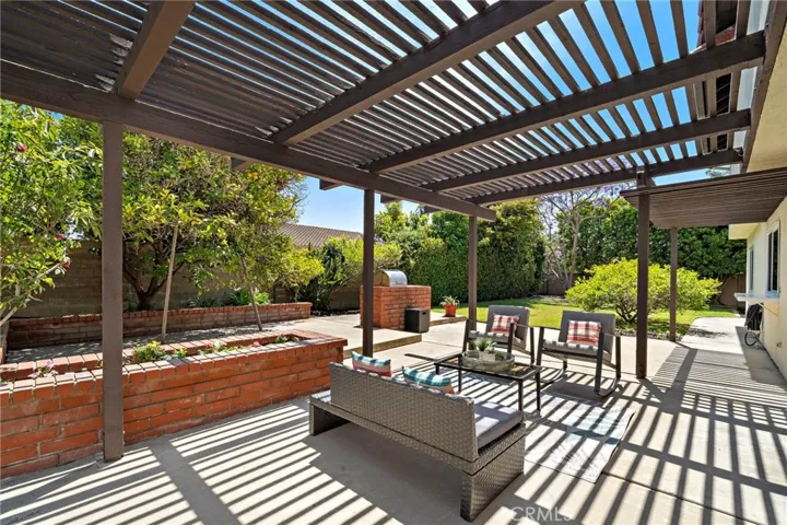 Step outside to your private backyard oasis—ideal for entertaining or relaxing—with a large covered patio, built-in BBQ, raised planters, fruit trees, and a lush lawn perfect for play