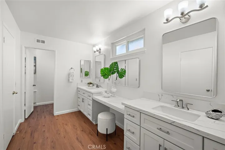 The luxurious primary suite includes a new spa-inspired ensuite bathroom with quartz counters, dual sinks, a sit-down vanity, updated mirrors and lighting